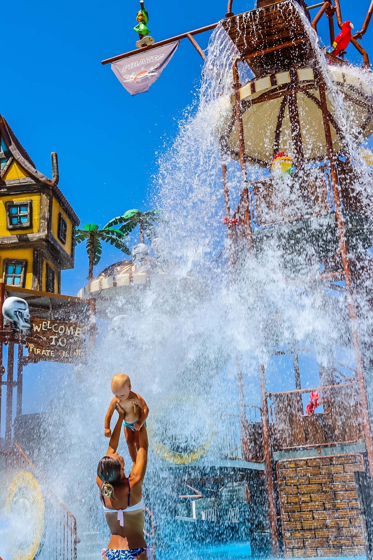 Children under the splash bucket at the aqua park