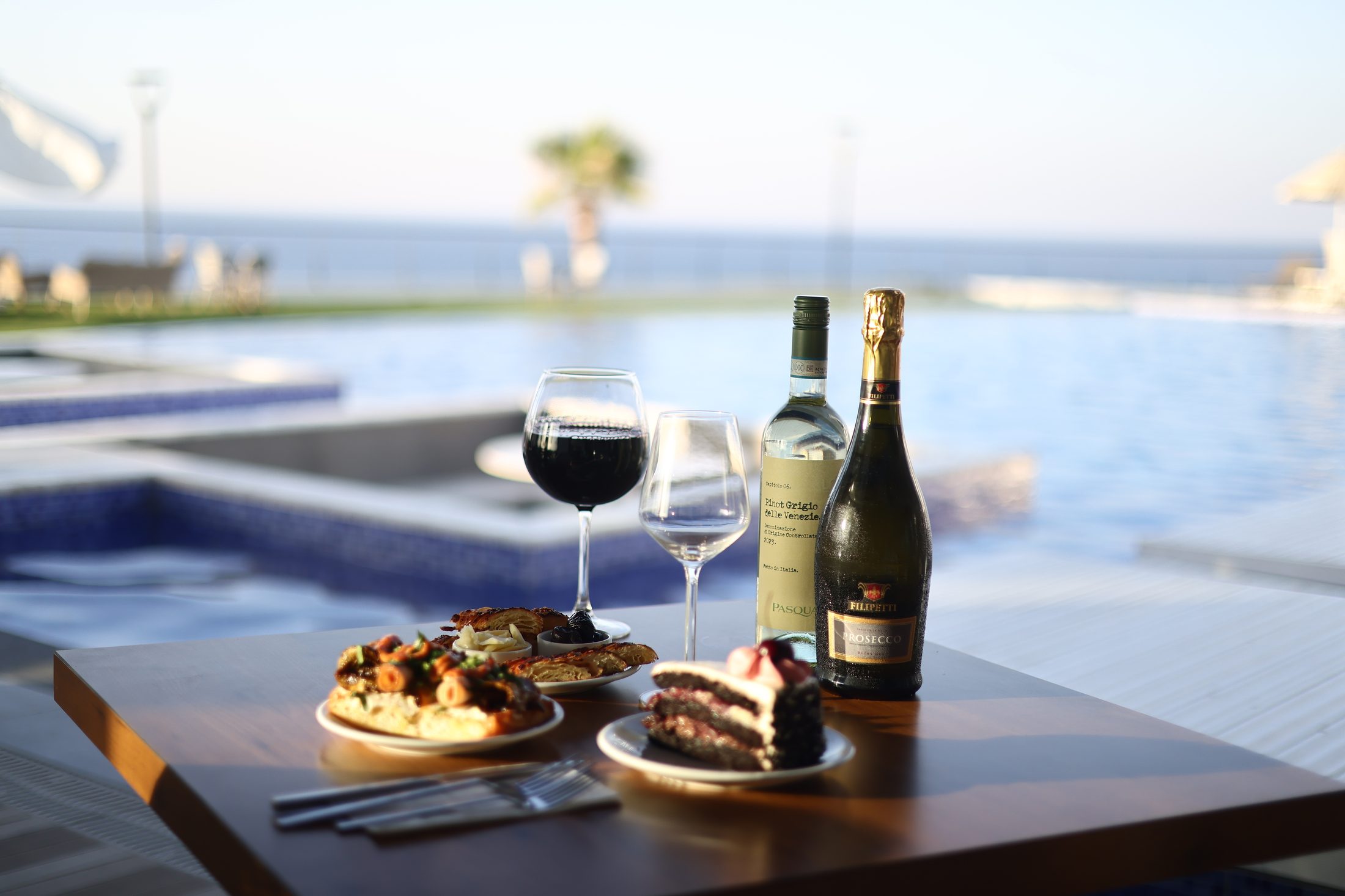 Wine and dessert by the pool at sunset